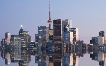 city skyline near body of water during night time